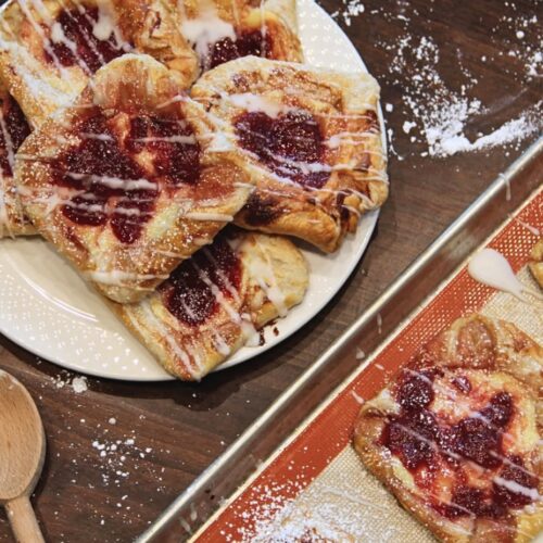 Alt Tag: alt="Freshly baked fruit danishes with red jam filling and white icing drizzle on a plate at Mabel Mae's at Head's Store.